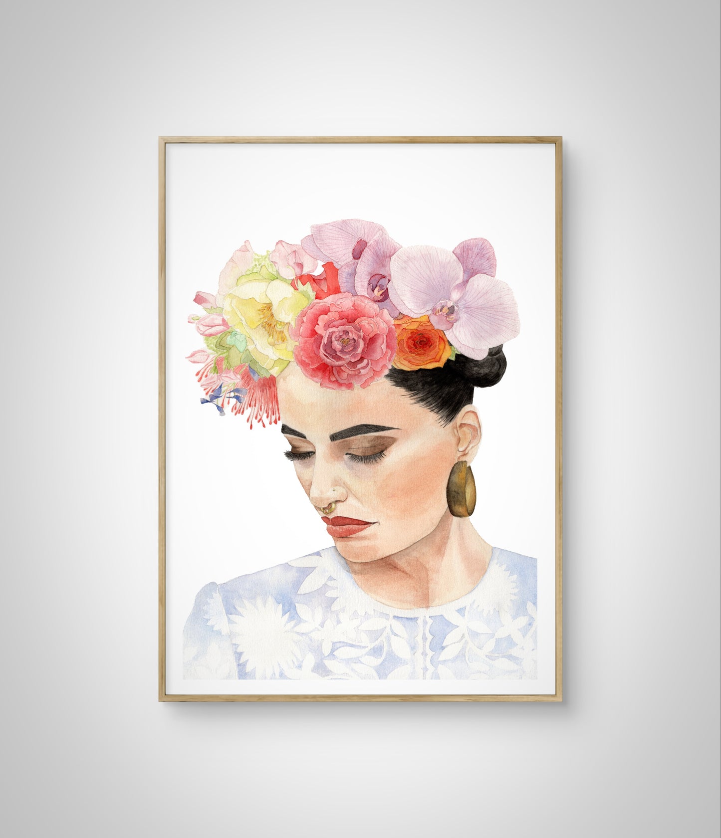 Framed watercolour portrait of woman with flower headdress inspired by Frida Kahlo hanging on white wall