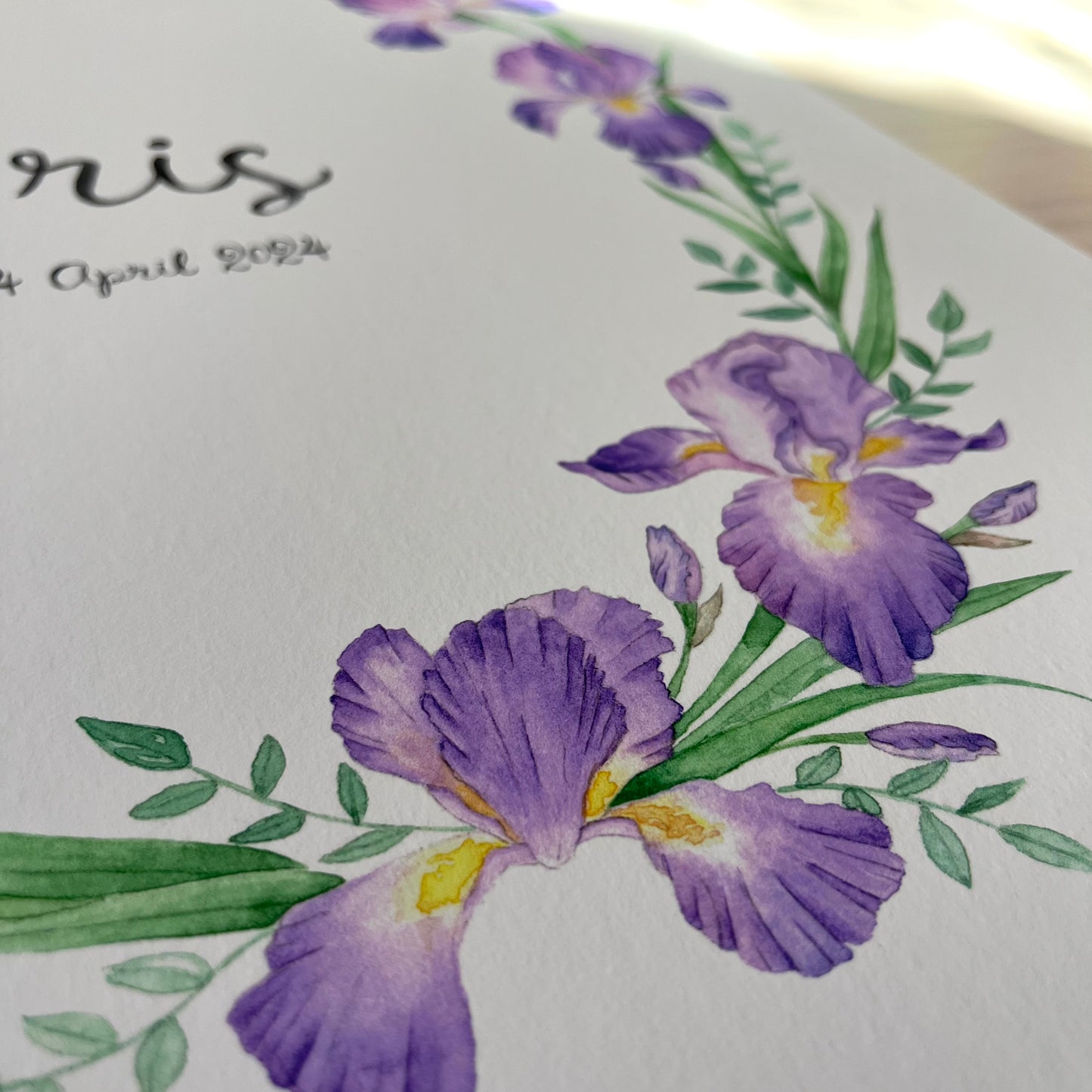 Name poster with purple iris flowers and green leaves on a light background.