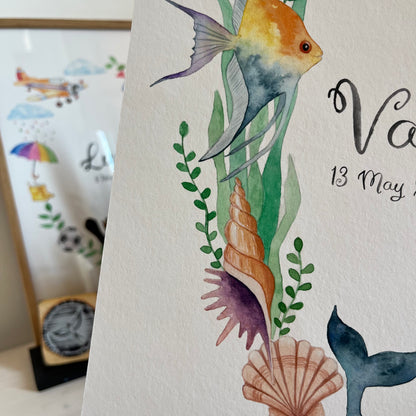 Closeup of Children's name poster with underwater-themed illustrations including fish, shells, and seaweed on a white background.