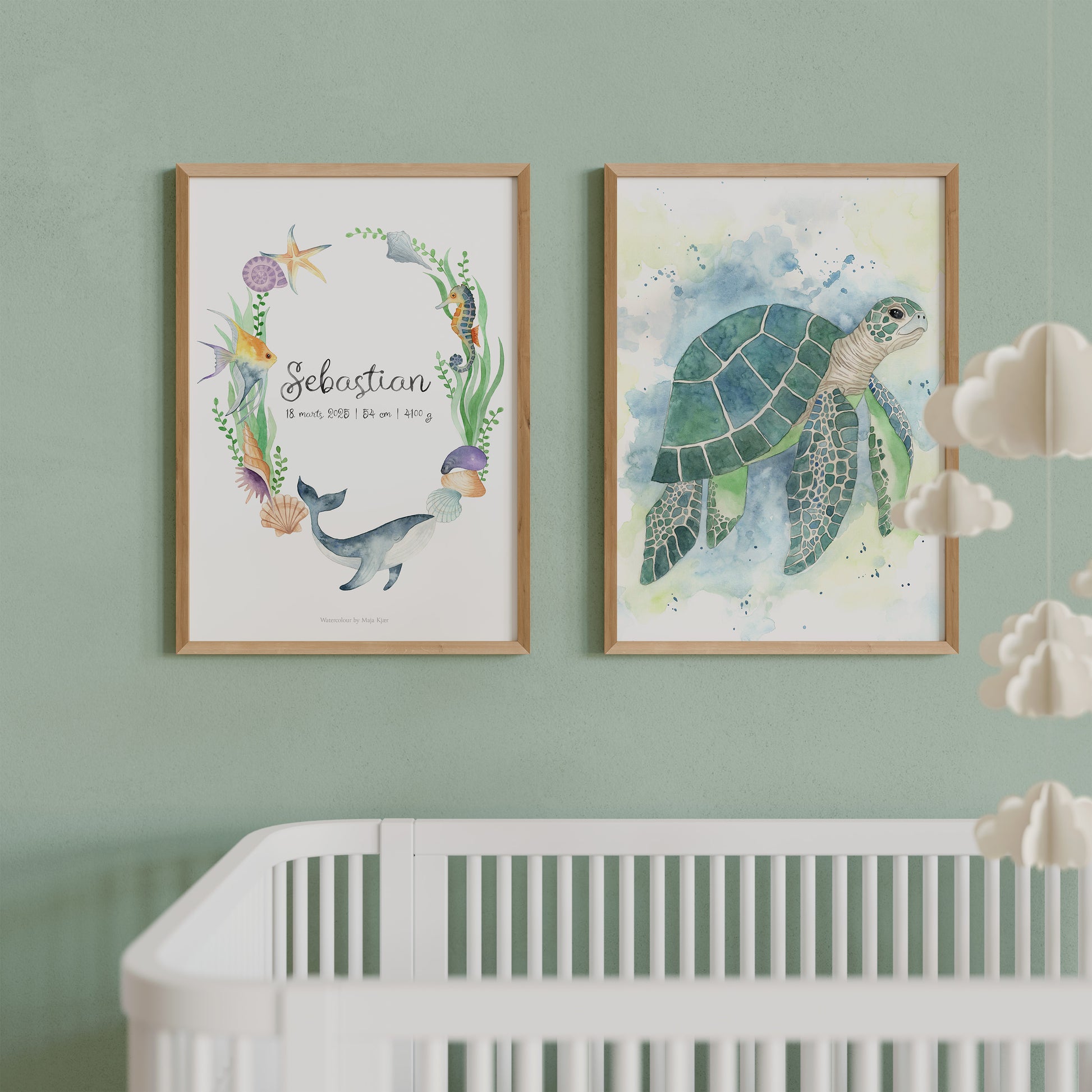 Framed artwork of a watercolour sea turtle and a baby name print with other sea creatures on a wall above a crib.