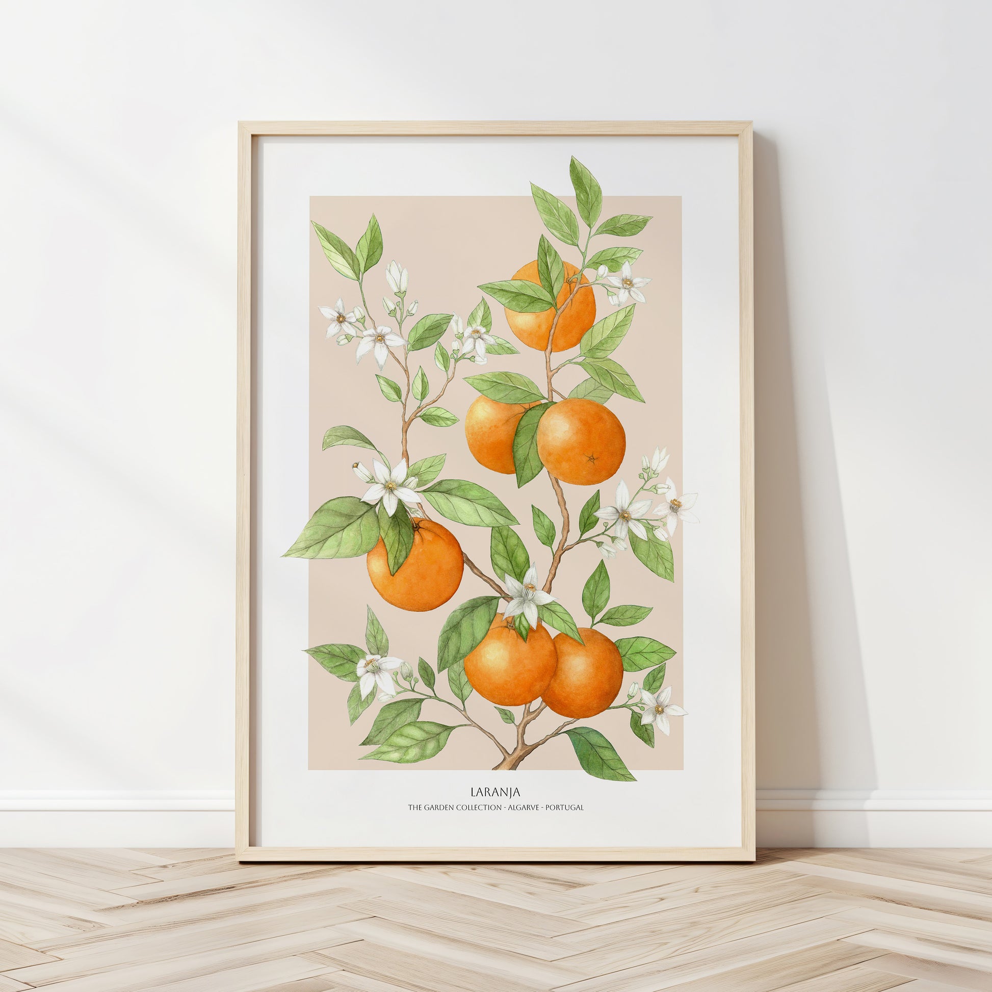 Framed artwork of oranges and leaves on a beige background