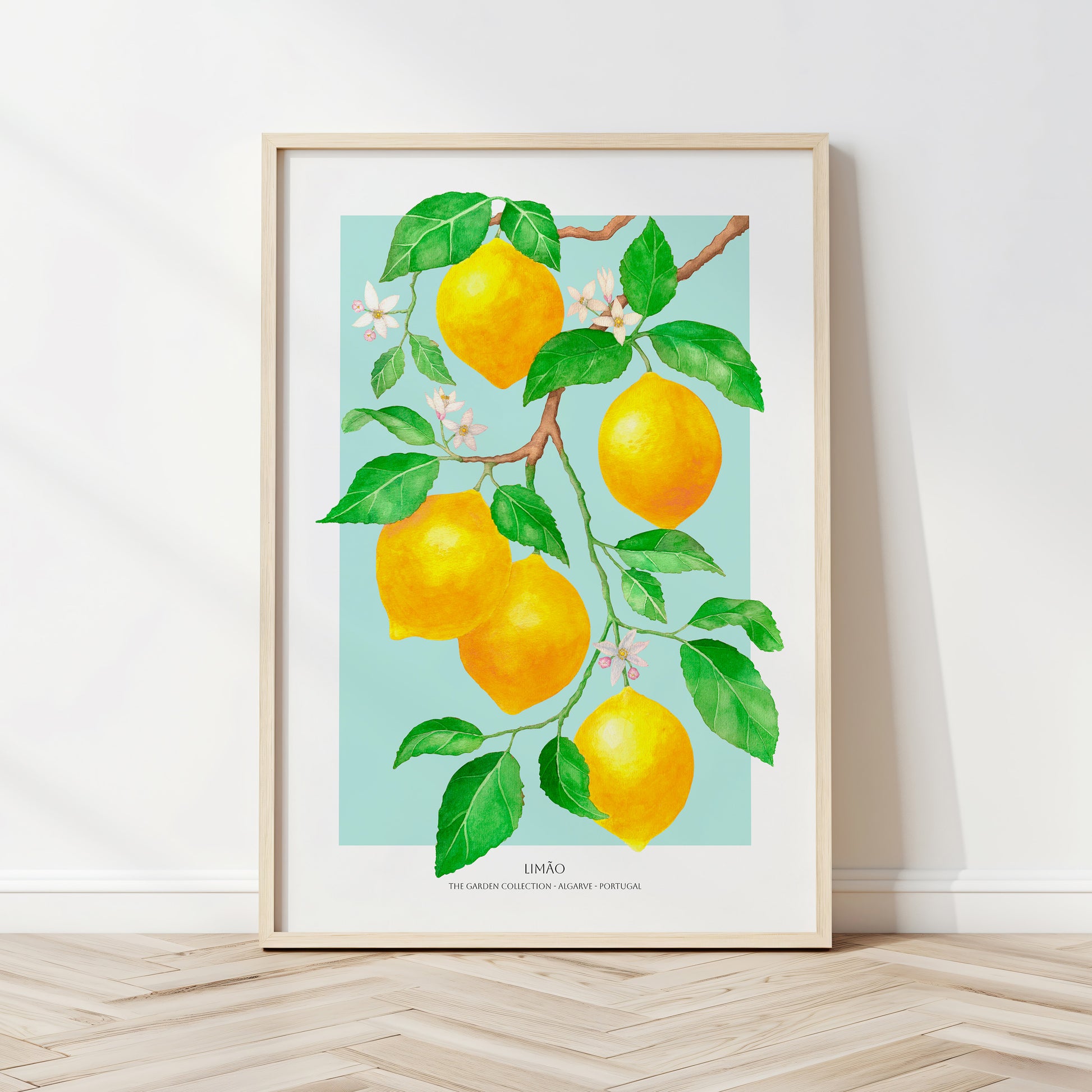 Framed artwork of lemons on a branch with leaves against a light blue background.