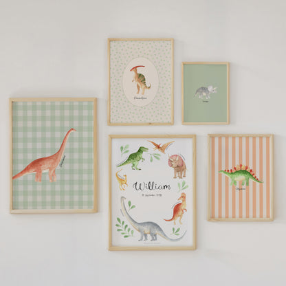 Five framed dinosaur-themed nursery wall art prints arranged on a white wall. The prints feature watercolor-style dinosaurs on pastel backgrounds, including green gingham, striped, and solid colors, with one personalized print reading 'William'.
