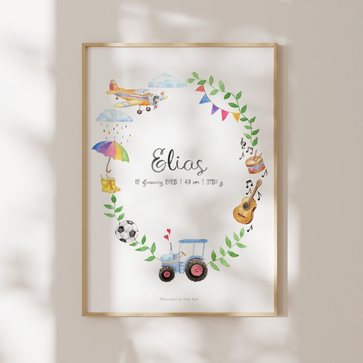 Framed artwork with colorful illustrations and the name 'Elias' on a light wall.