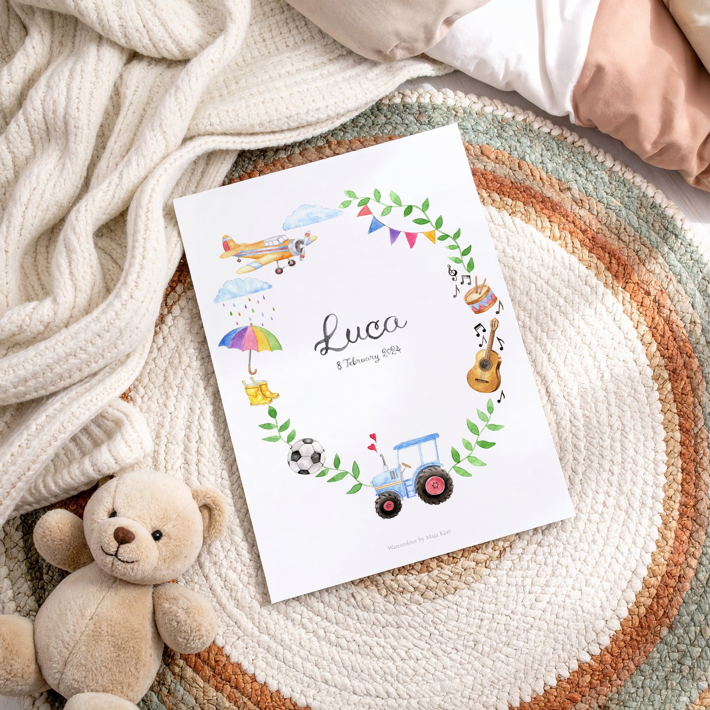 Baby name poster with illustrations of toys and a teddy bear on a textured surface