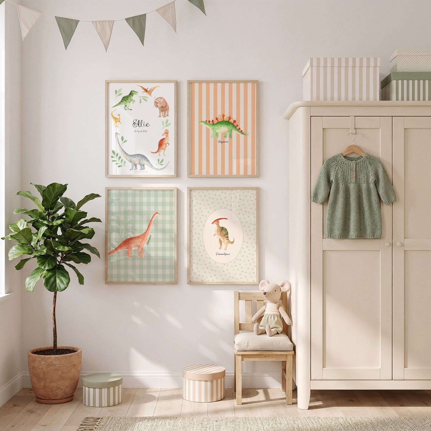 A styled children's room corner featuring four framed dinosaur-themed art prints on a white wall, next to a cream-colored wooden wardrobe with a green knit dress hanging on the door, a small wooden chair with a plush toy, a potted plant, and a string banner.