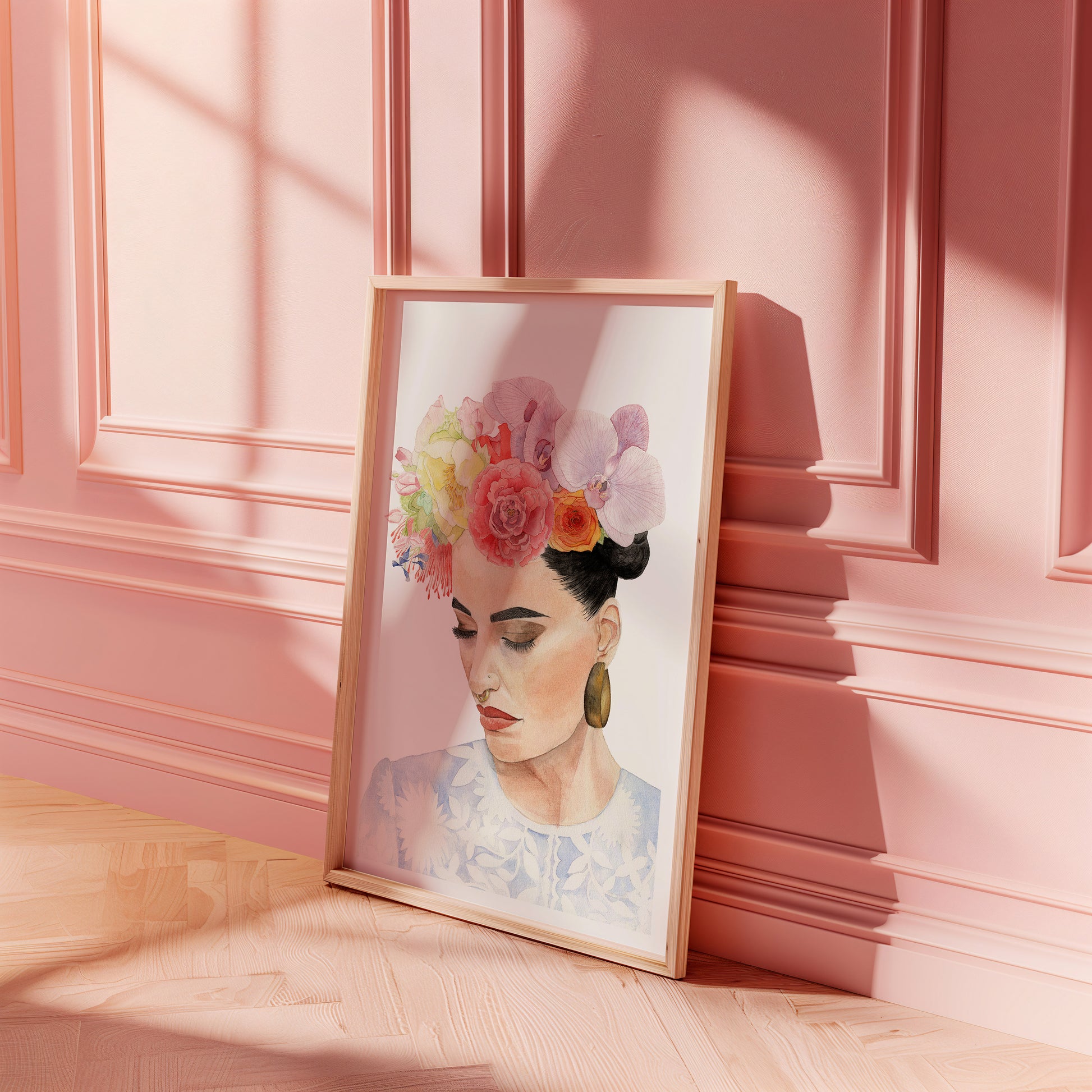 Framed artwork of a woman with flowers in her hair on a pink wall.
