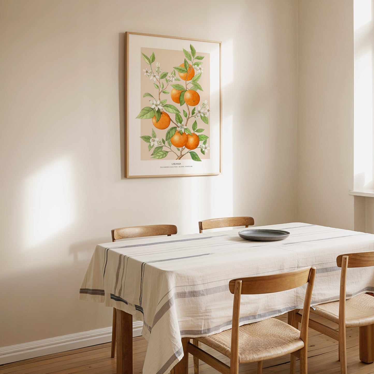 Dining room with wooden table and chairs, white tablecloth, and framed artwork on the wall.