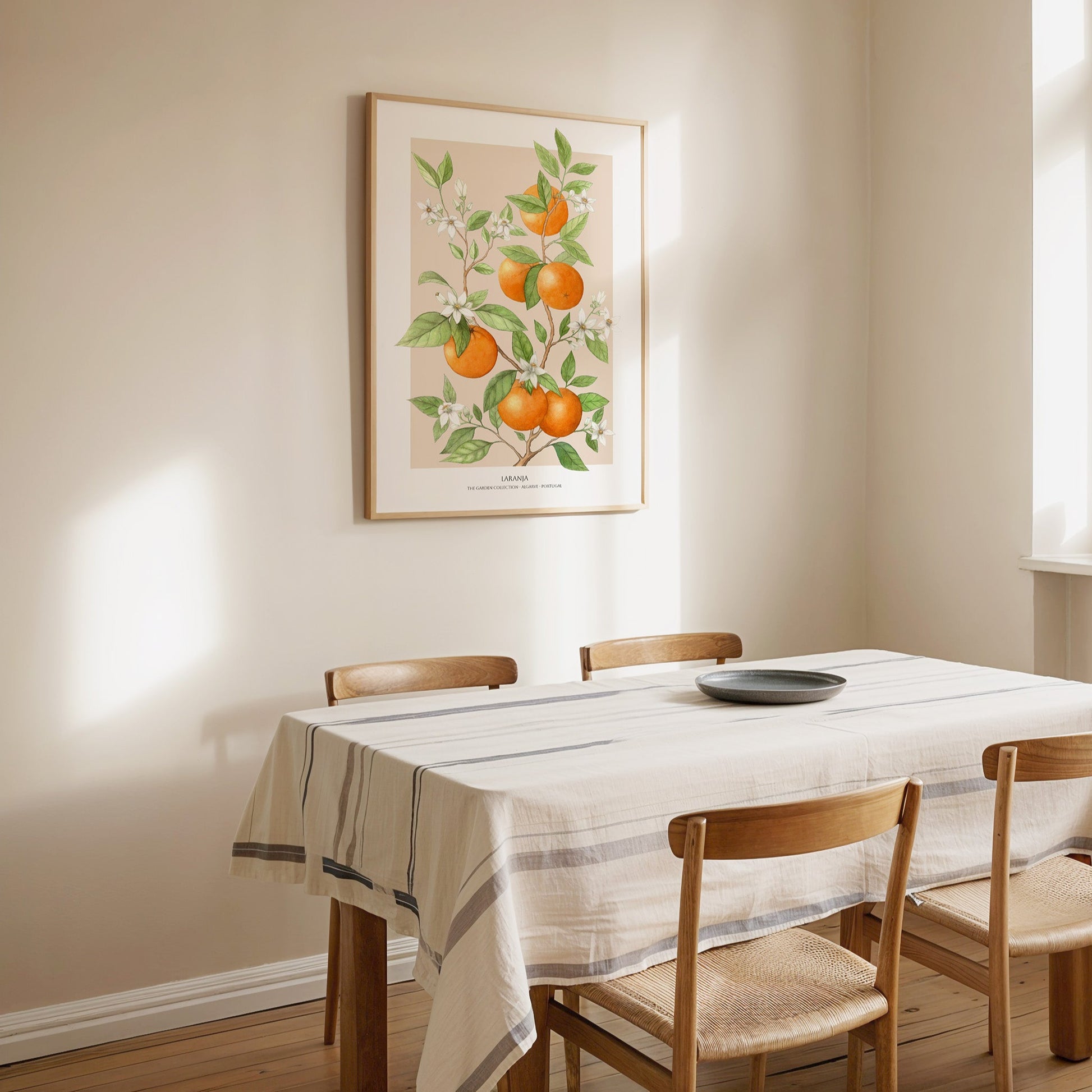 Dining room with wooden table and chairs, white tablecloth, and framed artwork on the wall.