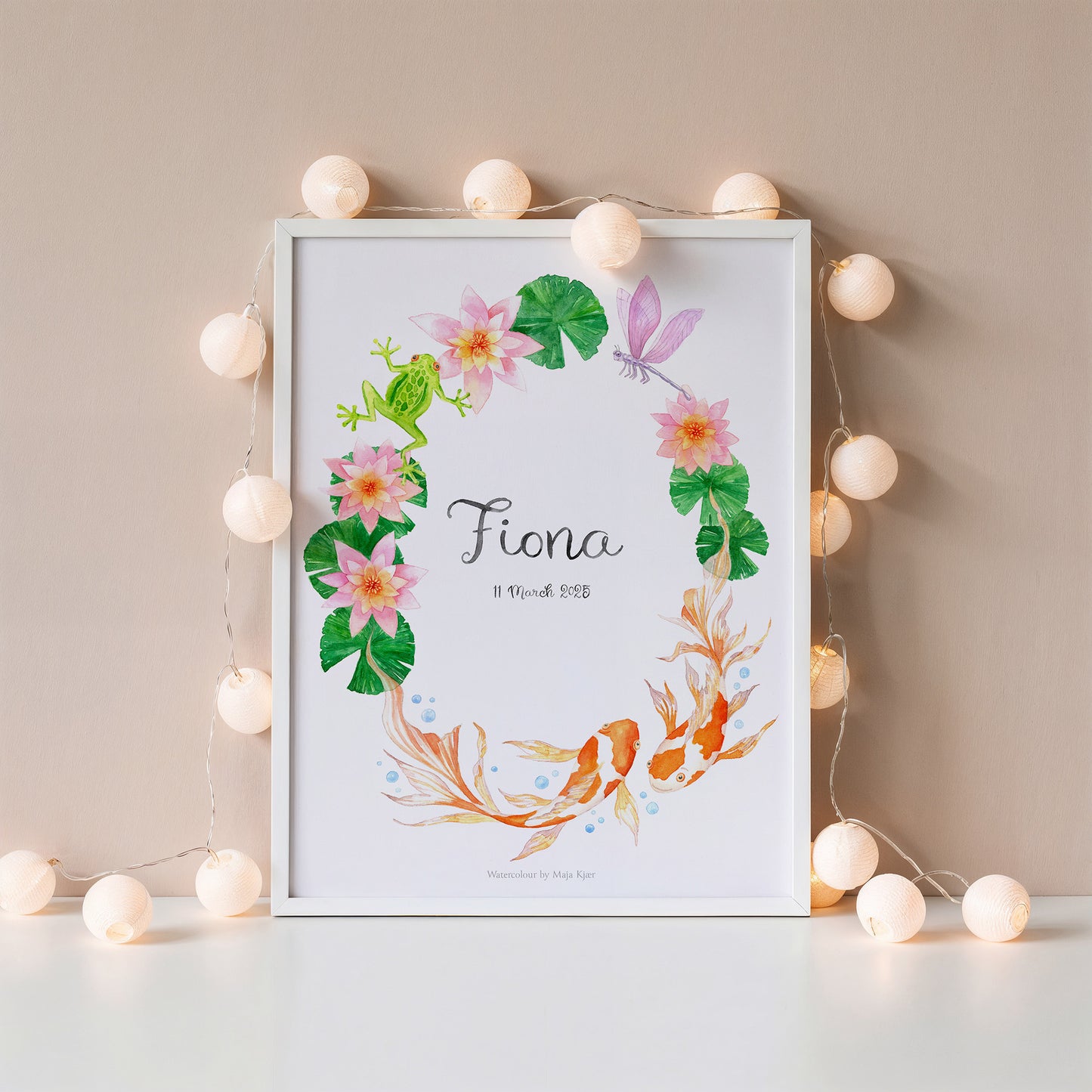Framed zodiac sign name poster for Pisces with koi carp and water lilies, with string lights against blush wall