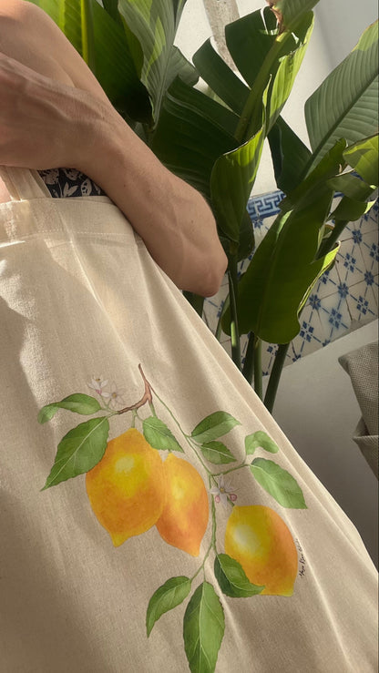 Lemon print tote bag in natural light with plant in background