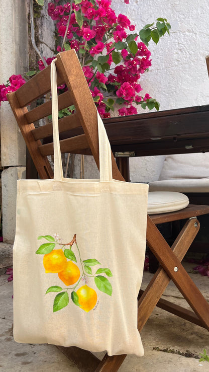 Lemon print tote bag hanging on chair outdoor setting