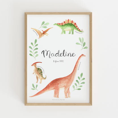 A framed personalized dinosaur art print featuring watercolor illustrations of dinosaurs and the name 'Madeline' in script, shown against a clean white background.