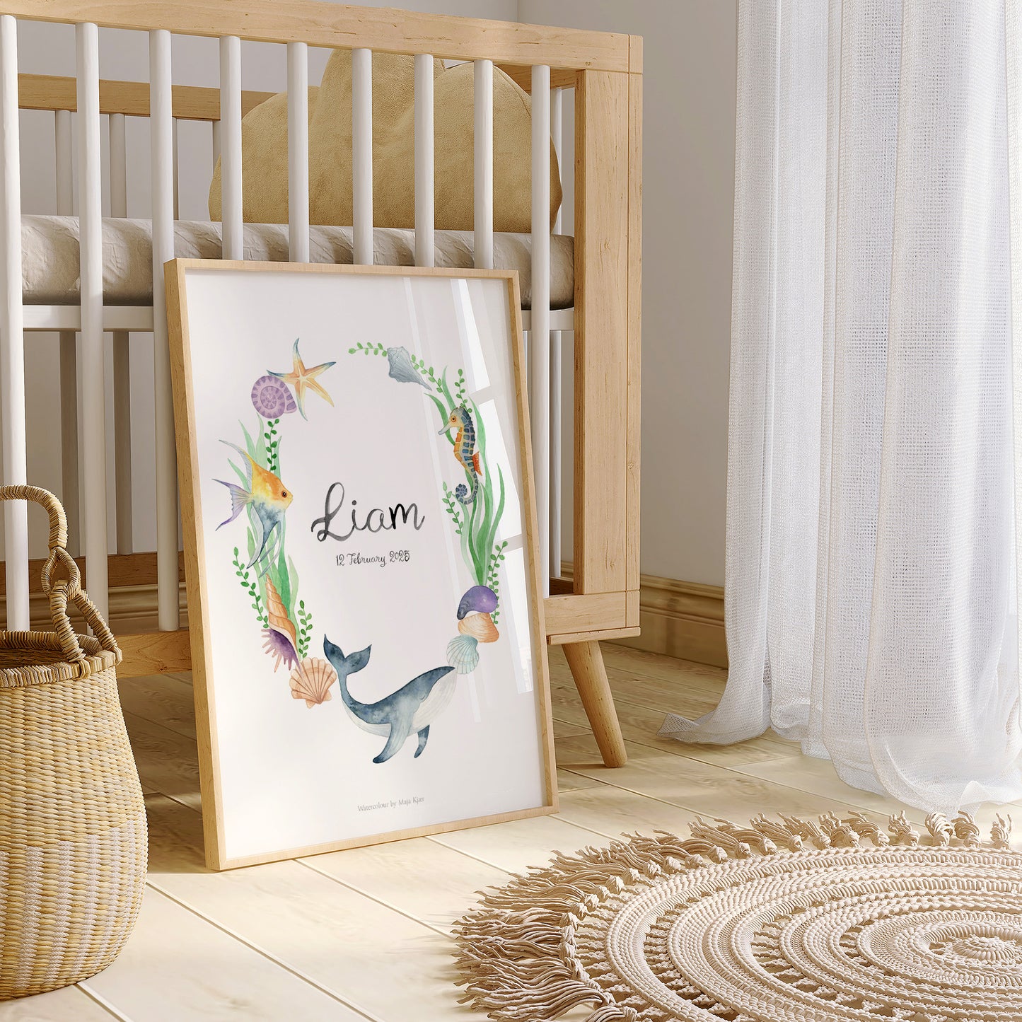 Framed artwork with 'Liam' in a nursery setting with a crib and basket.