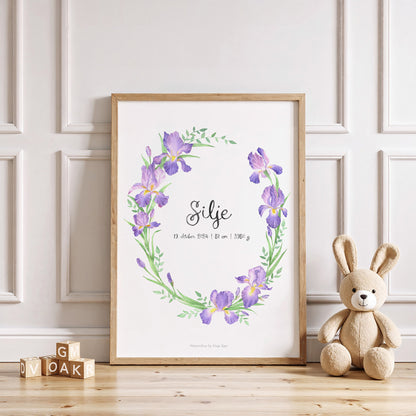 Framed floral print with a teddy bear and wooden blocks on a light wood floor.