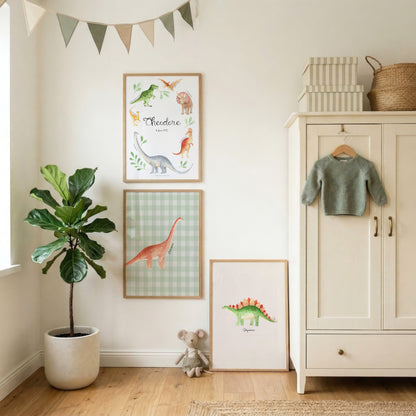 A styled children's room corner with three framed dinosaur-themed wall prints hanging on a white wall, a potted fiddle-leaf fig plant, a small stuffed mouse, a cream cabinet with a green sweater, and a bunting banner.
