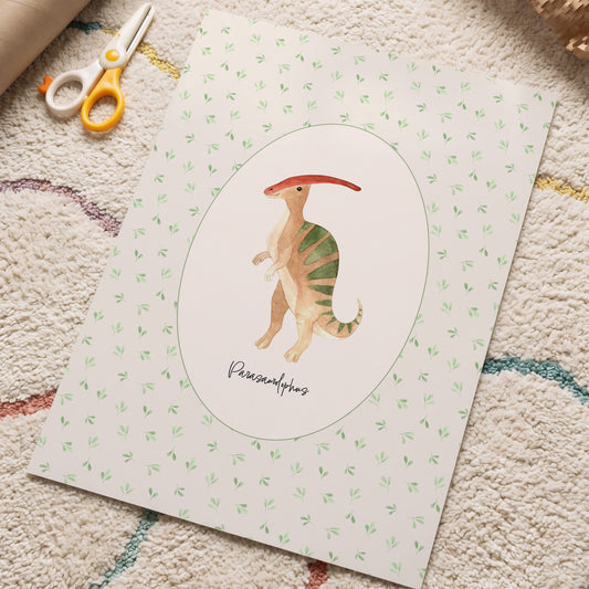 A square art print featuring a painted Parasaurolophus dinosaur in the center, surrounded by a white oval and a light green patterned border. The print is styled on a textured beige rug with craft scissors and a cardboard tube nearby.