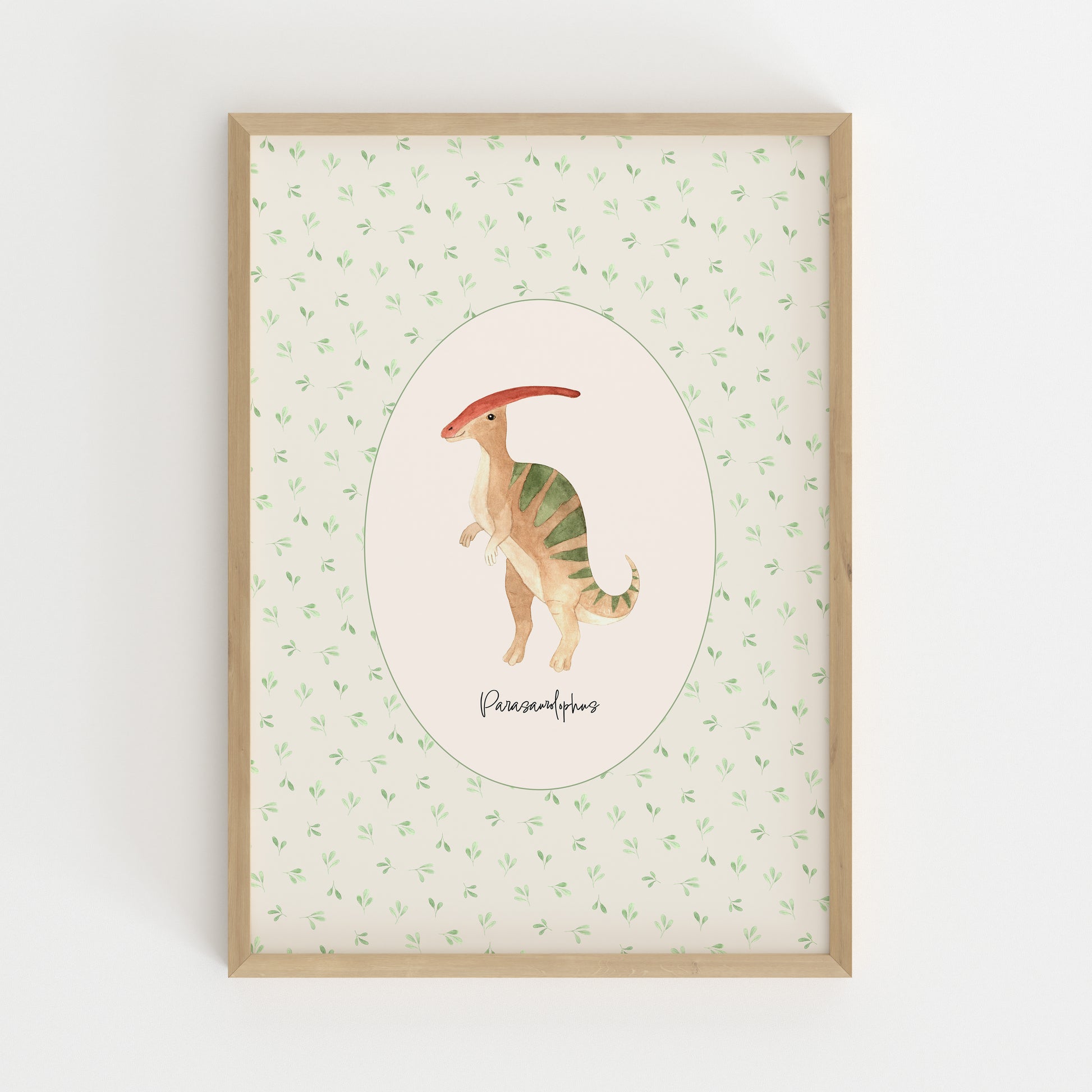 A framed art print featuring a watercolor illustration of a Parasaurolophus dinosaur in the center, surrounded by a light green leaf pattern on a cream background, enclosed in a natural wood frame.