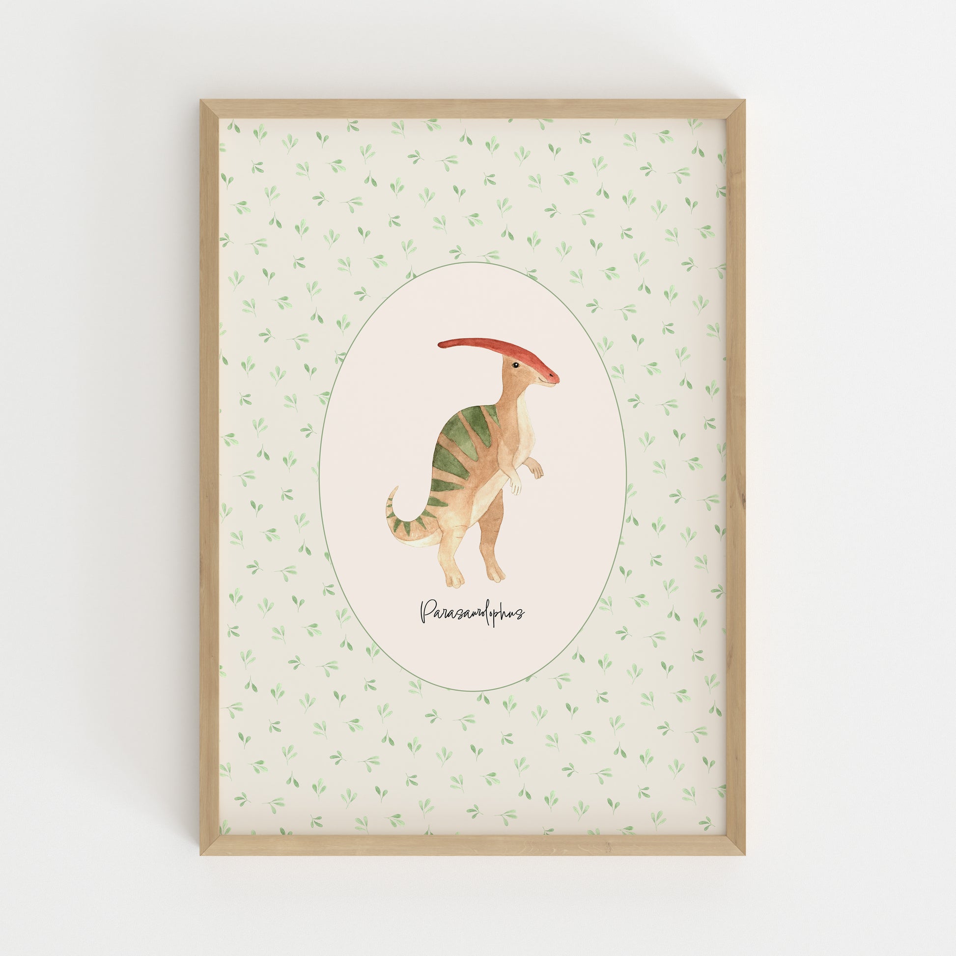 A framed children's art print featuring a watercolor illustration of a Parasaurolophus dinosaur inside an oval, set against a light green patterned background with a light wood frame.