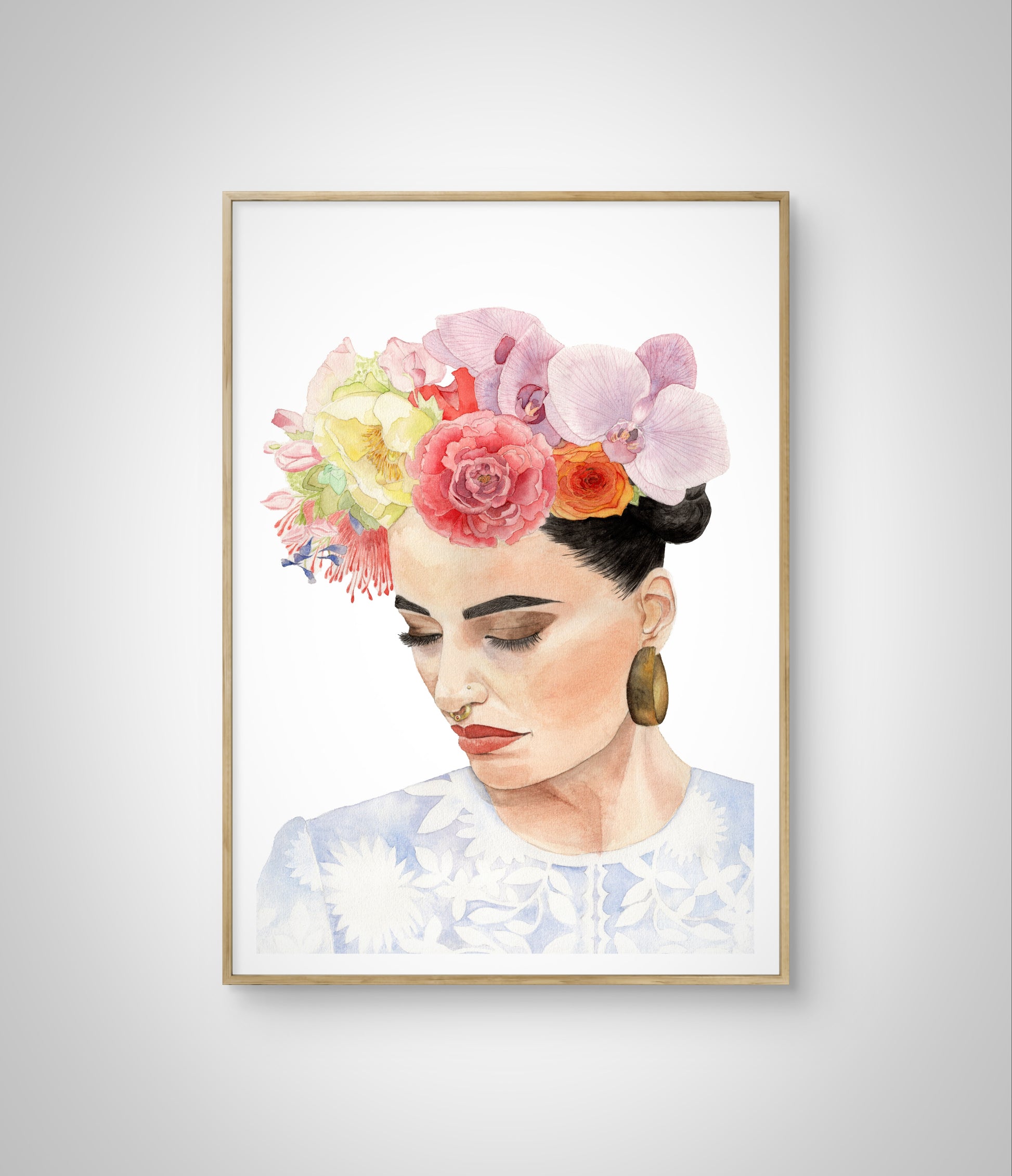 Framed watercolour portrait of woman with flower headdress inspired by Frida Kahlo hanging on white wall