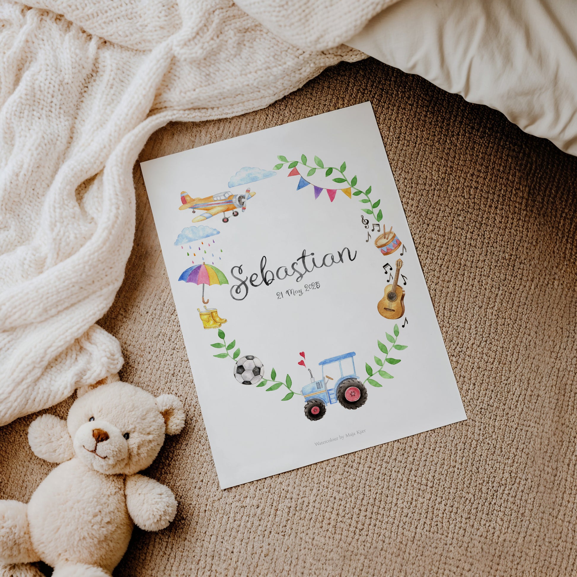 Baby name poster with illustrations of toys and a teddy bear on a textured surface