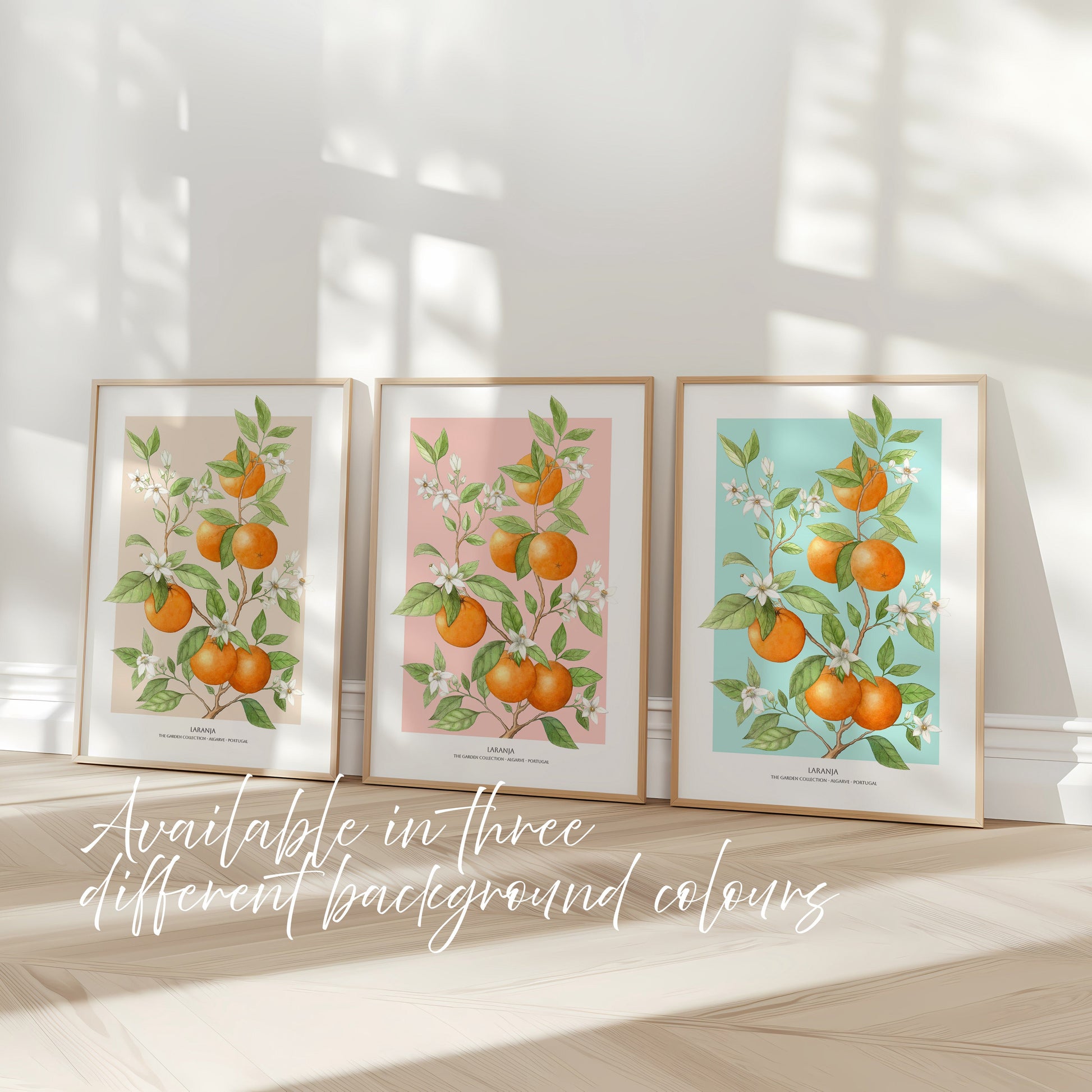 Three framed artworks with orange illustrations on a light wooden floor.