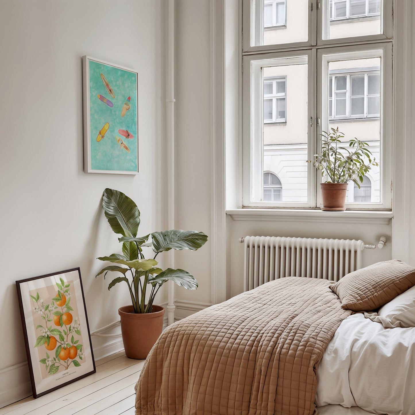 Cozy bedroom with a bed, plants, and framed artwork on a light-colored wall.