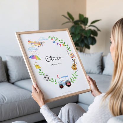 Person holding a framed children's name art print with illustrations of toys and objects.